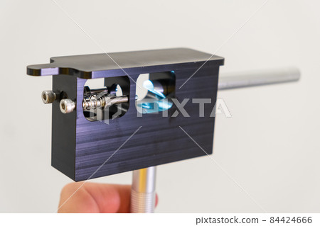 Scientist checking the condition of nebulizer needle from LC MS qTOF system using adjustment fixture and magnifier.  84424666