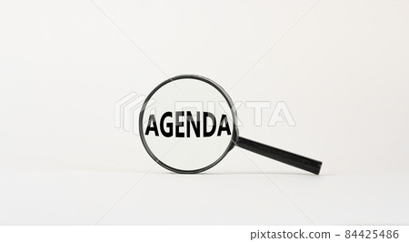 Agenda symbol. Magnifying glass with the concept word agenda on beautiful white background. Business and agenda concept, copy space. 84425486