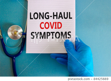 COVID-19 long-haul covid symptoms symbol. White card with words Long-haul covid symptoms. Doctor hand, stethoscope, blue background, copy space. Medical, COVID-19 long-haul covid symptoms concept. 84425669