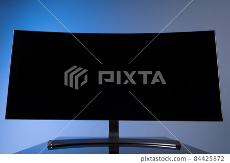 huge widescreen curved monitor with copy-space space on gray-blue background close-up huge widescreen curved monitor with copy-space space on gray-blue background close-up 84425872