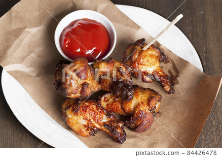 baked chicken wings together with ketchup 84426478