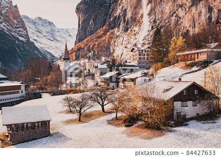 amazing touristic alpine village in winter with famous church and Staubbach waterfall  Lauterbrunnen  Switzerland  Europe 84427633