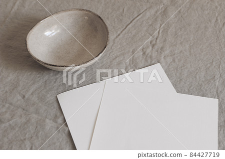 Closeup of empty paper sheets, pages mockups on beige table backgound. Office stationery concept. Modern minimalist template. Copy space. Ceramic bowl, organic shape. Branding identity. Closeup of empty paper sheets, pages mockups on beige table backgound. Office stationery concept. Modern minimalist template. Copy space. Ceramic bowl, organic shape. Branding identity. 84427719