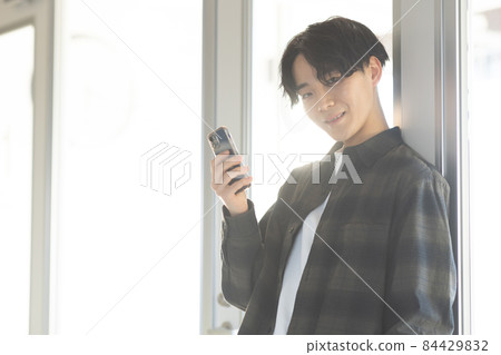 A refreshing young man with a smartphone A refreshing young man with a smartphone 84429832