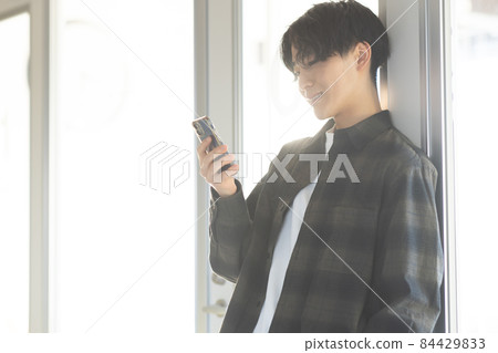 A refreshing young man with a smartphone A refreshing young man with a smartphone 84429833