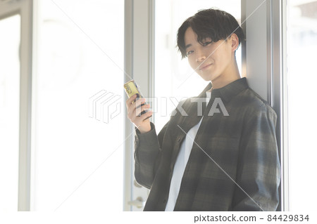 A refreshing young man with a smartphone 84429834