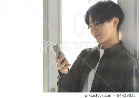 A refreshing young man with a smartphone A refreshing young man with a smartphone 84429835