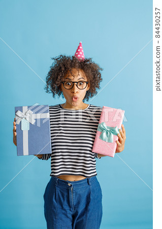 Afro American young woman holding birthday presents Afro American young woman holding birthday presents 84430257