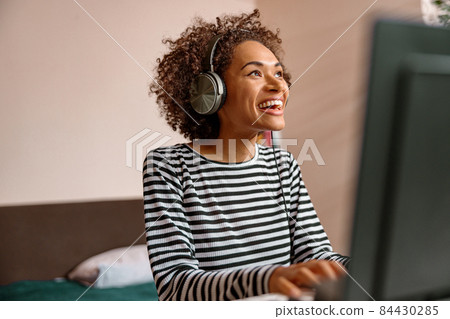 Happy joyful woman playing synthesizer at home 84430285