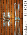 glasses with water and reflections on an orange checkered background 84430373
