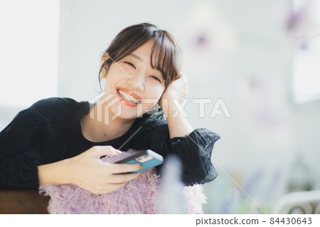 A woman watching a smartphone 84430643