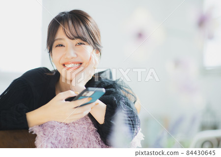A woman watching a smartphone A woman watching a smartphone 84430645