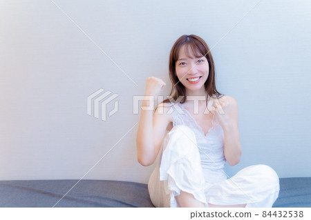 A woman who raises her fists with a smile A woman who raises her fists with a smile 84432538