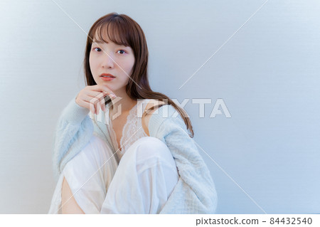 A woman sitting with her hand on her chin A woman sitting with her hand on her chin 84432540