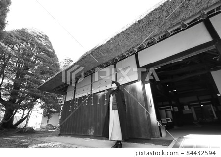 A woman next to a dried persimmon at the eaves of a private house while traveling A woman next to a dried persimmon at the eaves of a private house while traveling 84432594