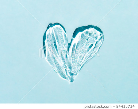 Transparent cosmetic gel heart shape on blue bg Transparent cosmetic gel heart shape on blue bg 84433734