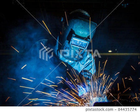worker with protective mask welding metal 84435774