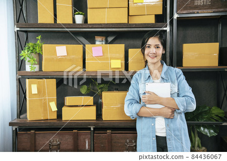 Asian woman startup small business at home office. Online seller entrepreneur young asian woman use tablet checking online order. Woman using tablet check stock goods supply delivery package shipping Asian woman startup small business at home office. Online seller entrepreneur young asian woman use tablet checking online order. Woman using tablet check stock goods supply delivery package shipping 84436067