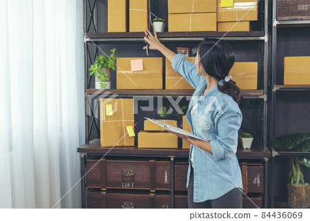 Woman checking stock goods supply delivery package shipping use document checklist. Asian woman startup small business at home office. Online entrepreneur asian woman use tablet checking online order Woman checking stock goods supply delivery package shipping use document checklist. Asian woman startup small business at home office. Online entrepreneur asian woman use tablet checking online order 84436069