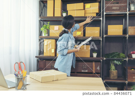 Woman checking stock goods supply delivery package shipping use document checklist. Asian woman startup small business at home office. Online entrepreneur asian woman use tablet checking online order Woman checking stock goods supply delivery package shipping use document checklist. Asian woman startup small business at home office. Online entrepreneur asian woman use tablet checking online order 84436071