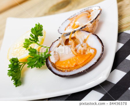 Raw dog cockles with lemon and greens 84436378