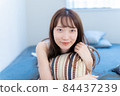 A woman smiling while lying in bed 84437239
