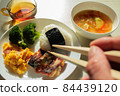 Hands pointing chopsticks at one plate rice with rice balls 84439120