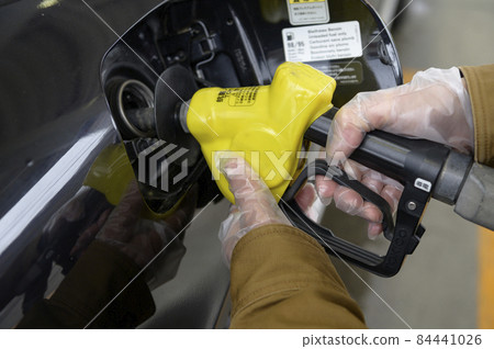 A person who refuels a car 84441026