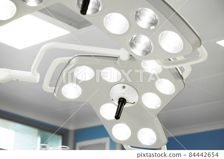 Two surgical lamps in operation room. Blue cast light represent purity and clinical mood. Useful file for your hospital brochure, medical article and other purpose Two surgical lamps in operation room. Blue cast light represent purity and clinical mood. Useful file for your hospital brochure, medical article and other purpose 84442654