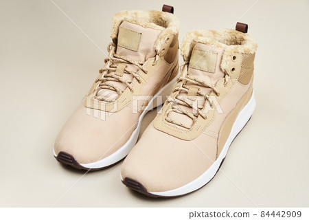 Male winter shoes on beige background Male winter shoes on beige background 84442909