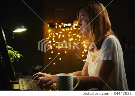 Tired woman works late at home workplace Tired woman works late at home workplace 84442921