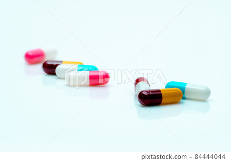 Multi-color pills on white background. Antibiotic capsule pills. Prescription drugs. Pharmaceutical industry. Polypharmacy concept. Capsule manufacturing. Healthcare and medicine. Antimicrobial drugs. Multi-color pills on white background. Antibiotic capsule pills. Prescription drugs. Pharmaceutical industry. Polypharmacy concept. Capsule manufacturing. Healthcare and medicine. Antimicrobial drugs. 84444044
