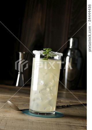 Salty dog, shaker, measure cup and bar spoon with mint cocktail with salt on the edge of the glass Salty dog, shaker, measure cup and bar spoon with mint cocktail with salt on the edge of the glass 84444486