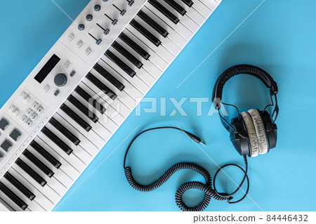 Headphones and keys on a blue background, top view. Headphones and keys on a blue background, top view. 84446432