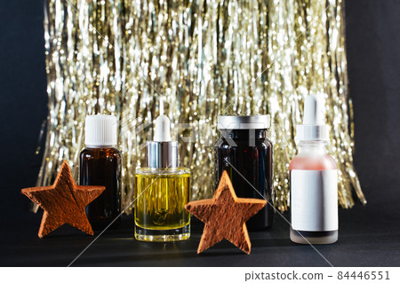 face oil, essential oil and beauty suppliments on tincel lametta background with coconut stars face oil, essential oil and beauty suppliments on tincel lametta background with coconut stars 84446551