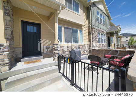 Front door exterior of townhouse with outdoor patio and window well of basement window Front door exterior of townhouse with outdoor patio and window well of basement window 84446870