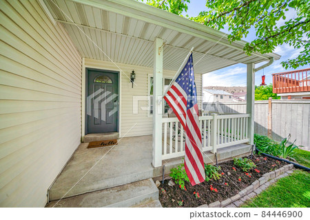 Facade of an entrance of a house house with USA flag at the front 84446900
