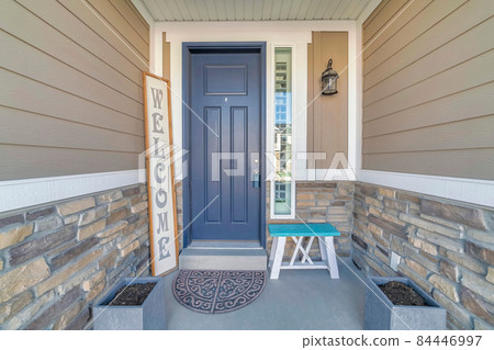 Gray front door exterior with lockbox on the knob and welcome signboad 84446997