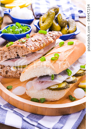 Dutch herring. Toast with Dutch herring, onions, pickles. Traditional rustic appetizer with seafood Dutch herring. Toast with Dutch herring, onions, pickles. Traditional rustic appetizer with seafood 84447234