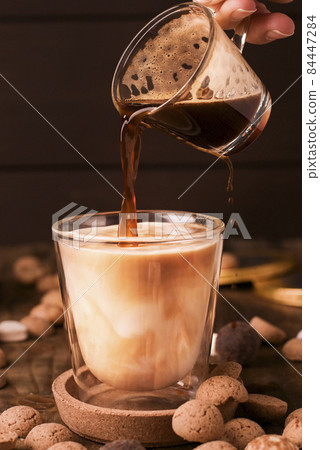 latte, espresso coffee pouring into milk. Dutch holiday Sinterklaas. kruidnoten cookies sweets 84447284