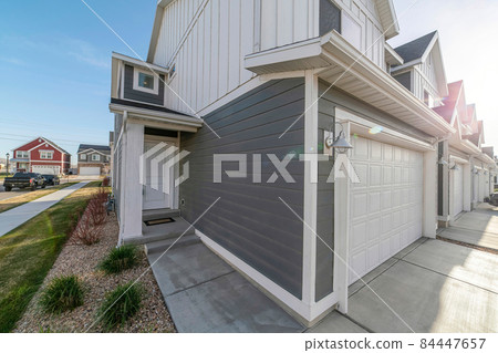 Side view of an exterior of a townhouses with gray and white color palette 84447657