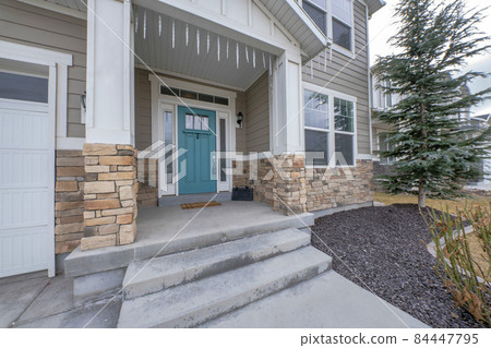 House exterior decorated with ornamental lighting and large front yard garden with pine and gravel 84447795