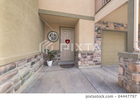 Exterior of a house with stone bricks and a garage door on the side 84447797