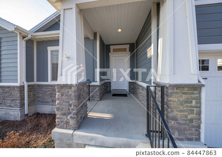 Exterior of an entrance of a house with wooden and stone bricks siding 84447863