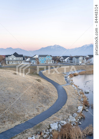 Top view of a clean paved curved path near the rocky shore of a lake 84448314