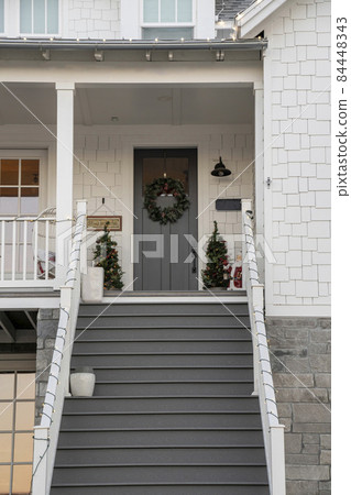 Gray staircase leading to a gray front door of a house 84448343
