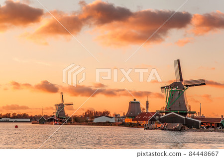 Traditional Dutch windmills against colorful sunset in Zaanse Schans, Amsterdam area, Holland 84448667