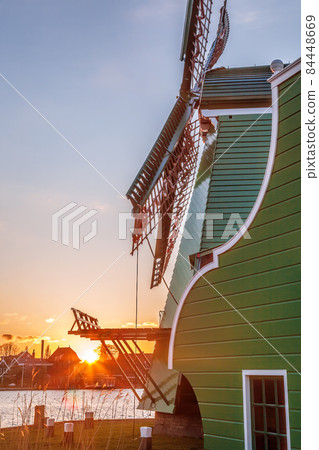 Traditional Dutch windmills against colorful sunset in Zaanse Schans, Amsterdam area, Holland 84448669