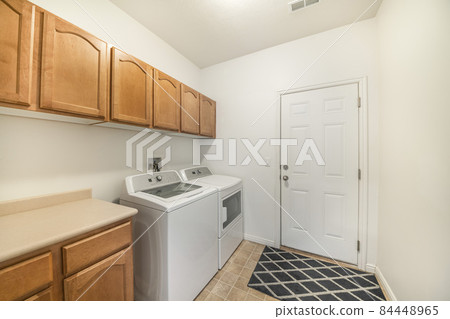 Laundry room with wooden wall cabinets and drawers Laundry room with wooden wall cabinets and drawers 84448965