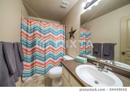 Bathroom interior with vanity sink and colorful zigzag patterned shower curtain Bathroom interior with vanity sink and colorful zigzag patterned shower curtain 84449048